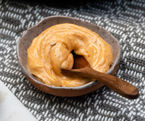 ORANGE SAUCE IN A BOWL WITH WOODEN SPOON 